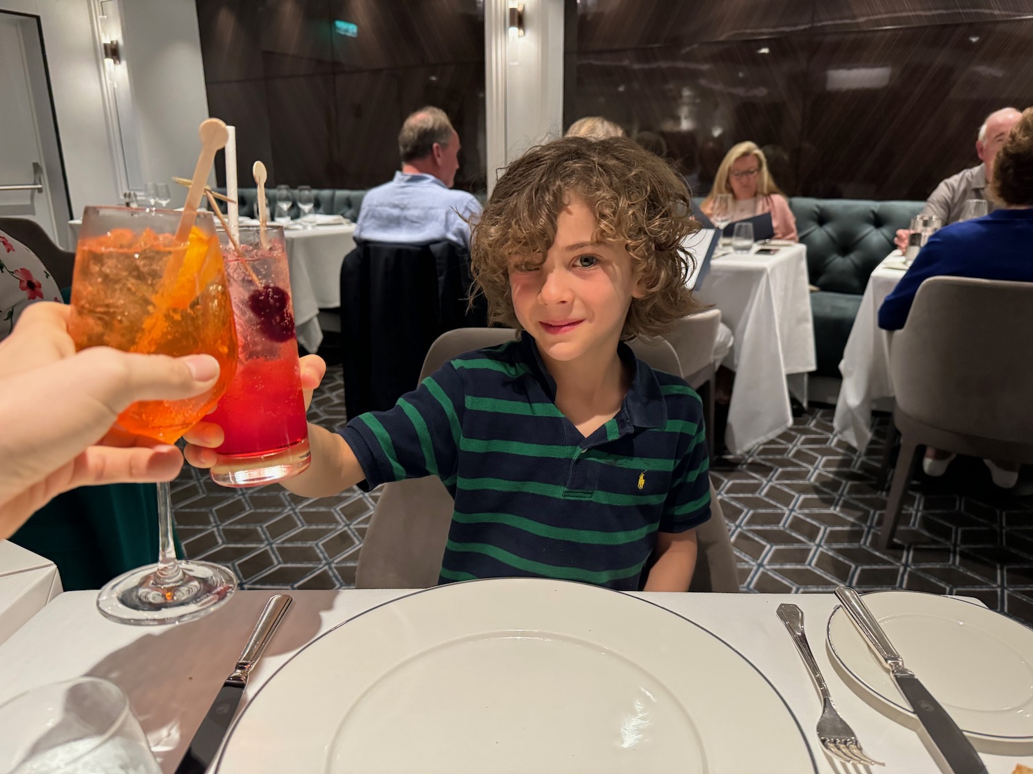 a boy holding drinks in a restaurant