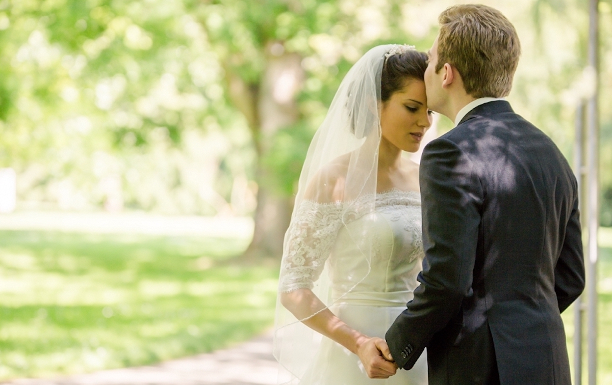 a man and woman in wedding attire kissing