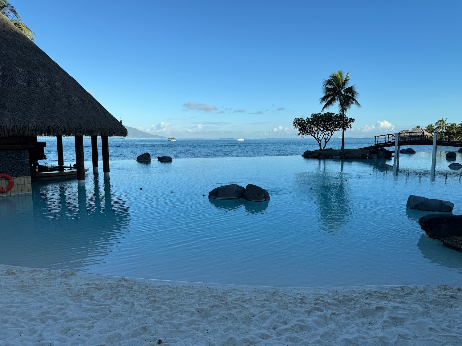 a body of water with a hut and rocks in it