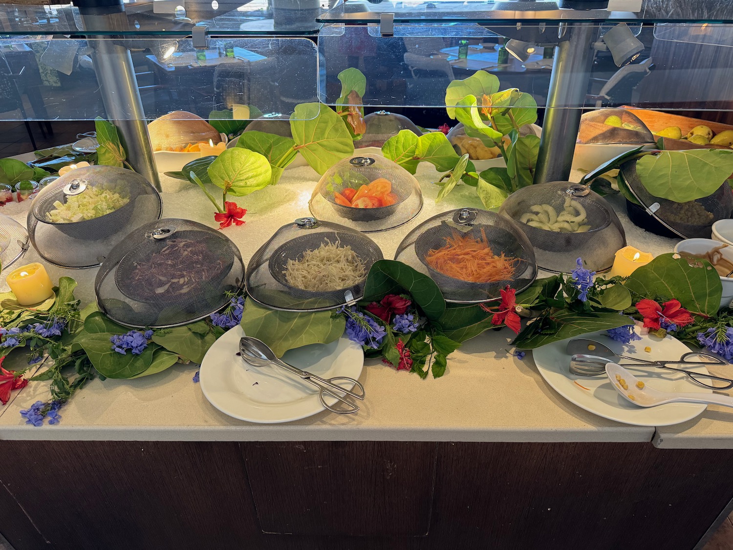 a buffet with plates of food and flowers