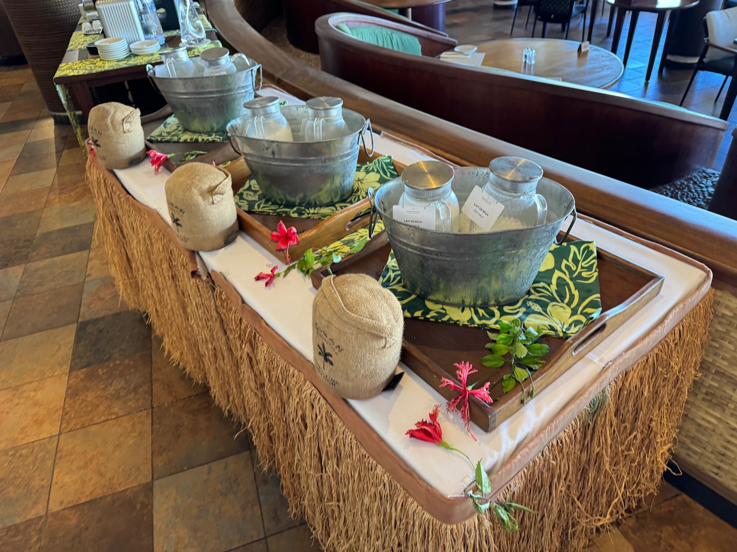 a table with straw and metal bowls and straw tablecloths