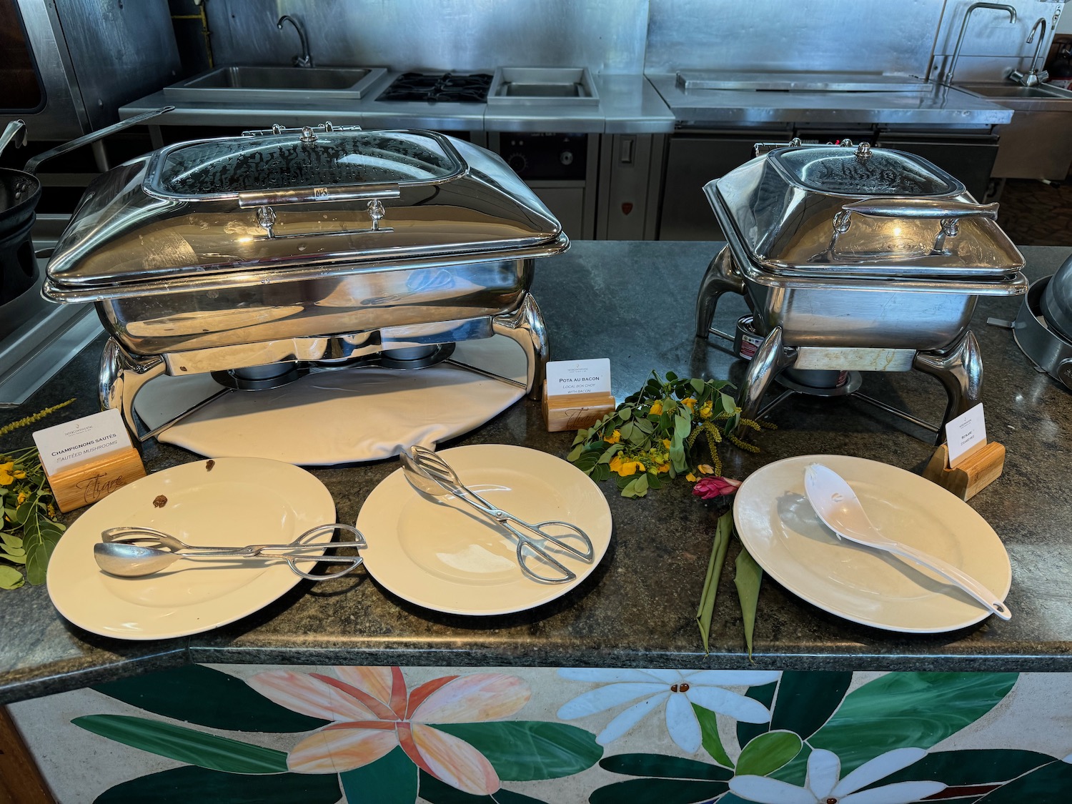 a buffet with plates and utensils on a counter