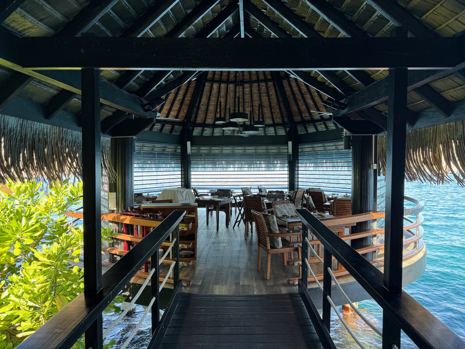 a gazebo with chairs and tables on the water