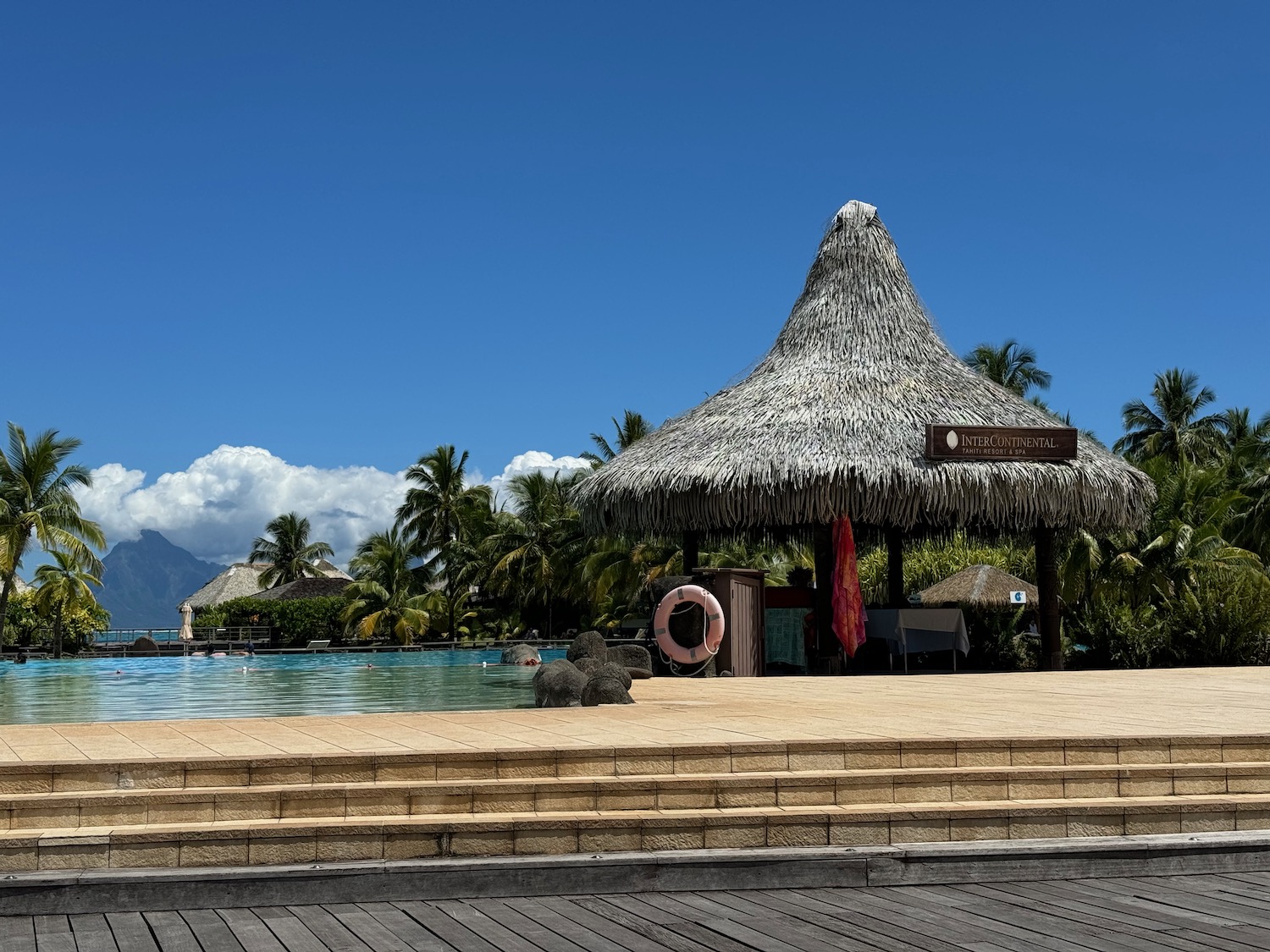 a pool with a hut and a life preserver