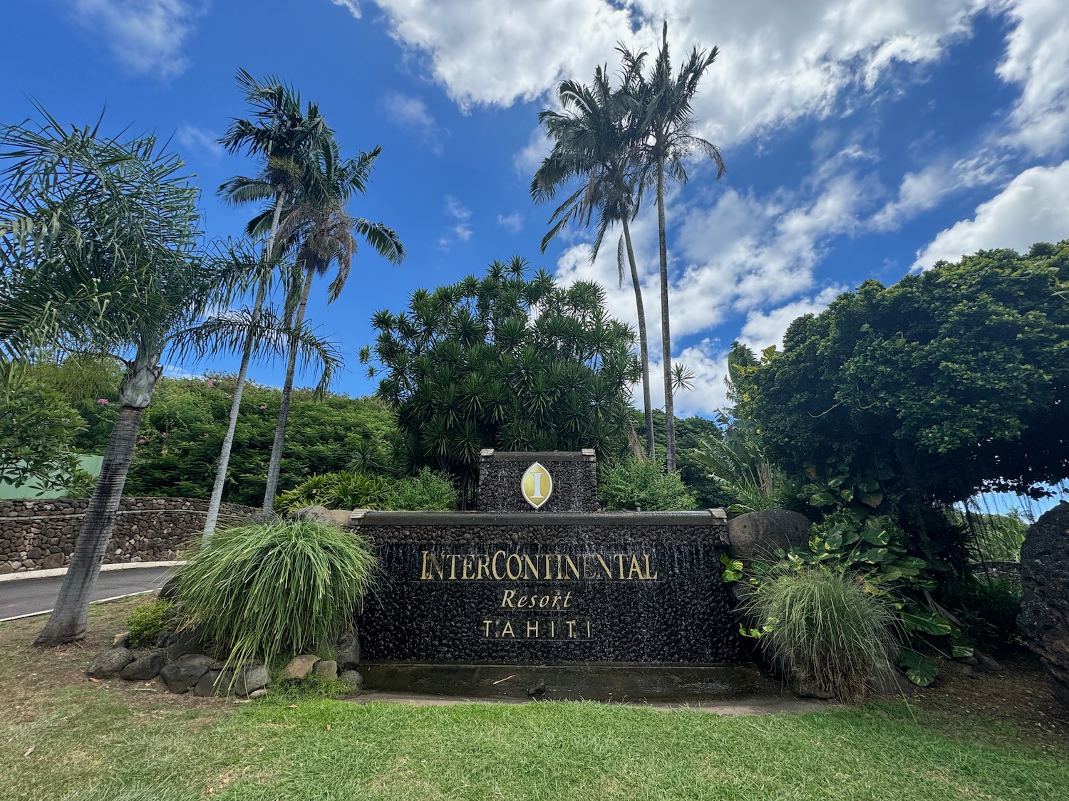 a sign with palm trees and blue sky