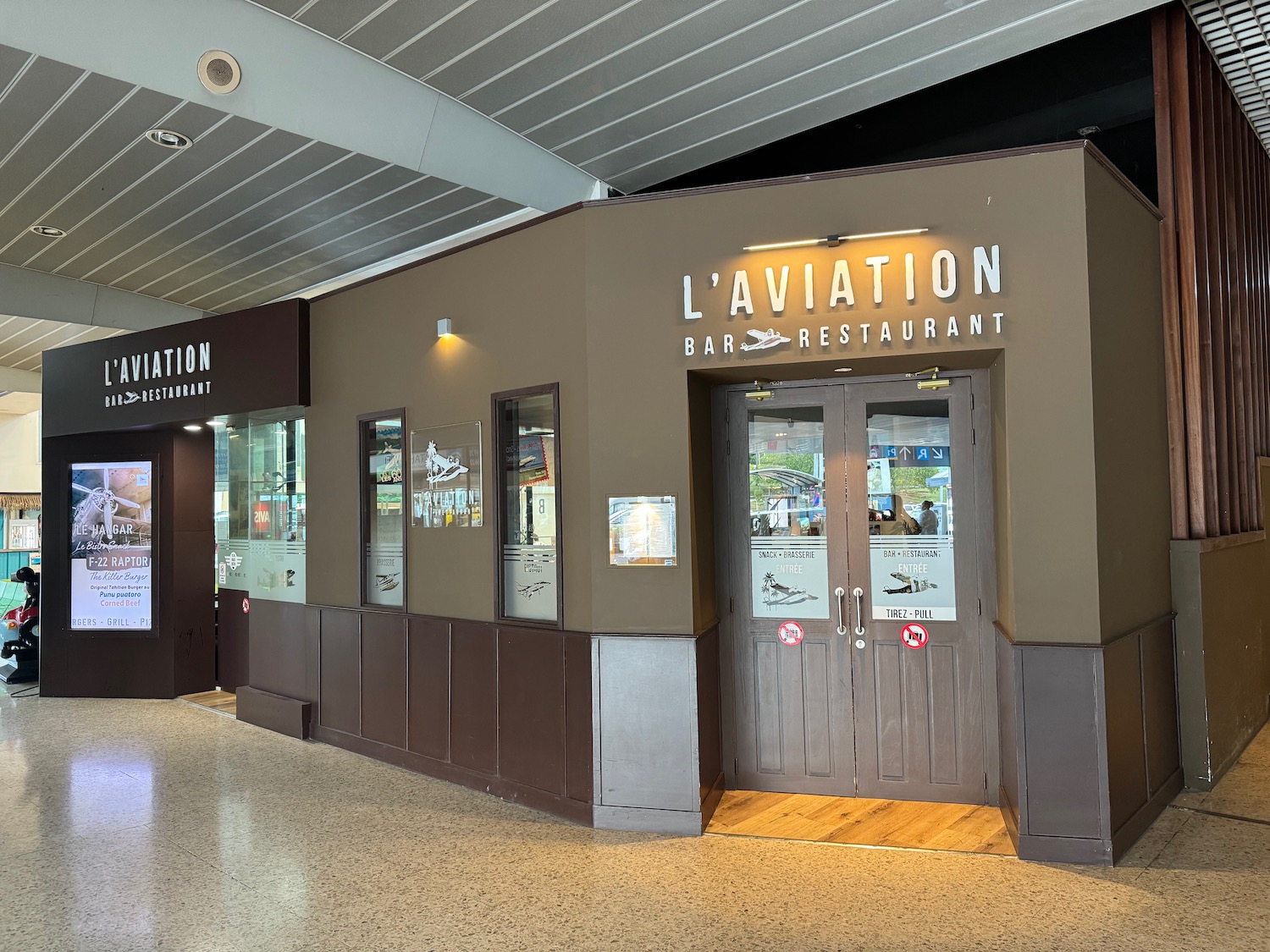 a restaurant with signs on the front