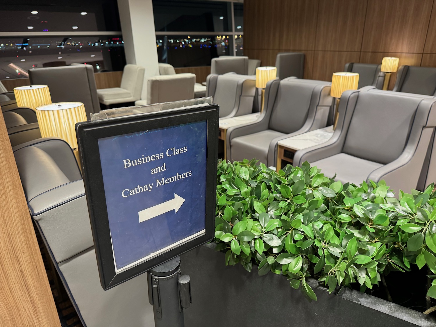 a sign in a room with chairs and a plant