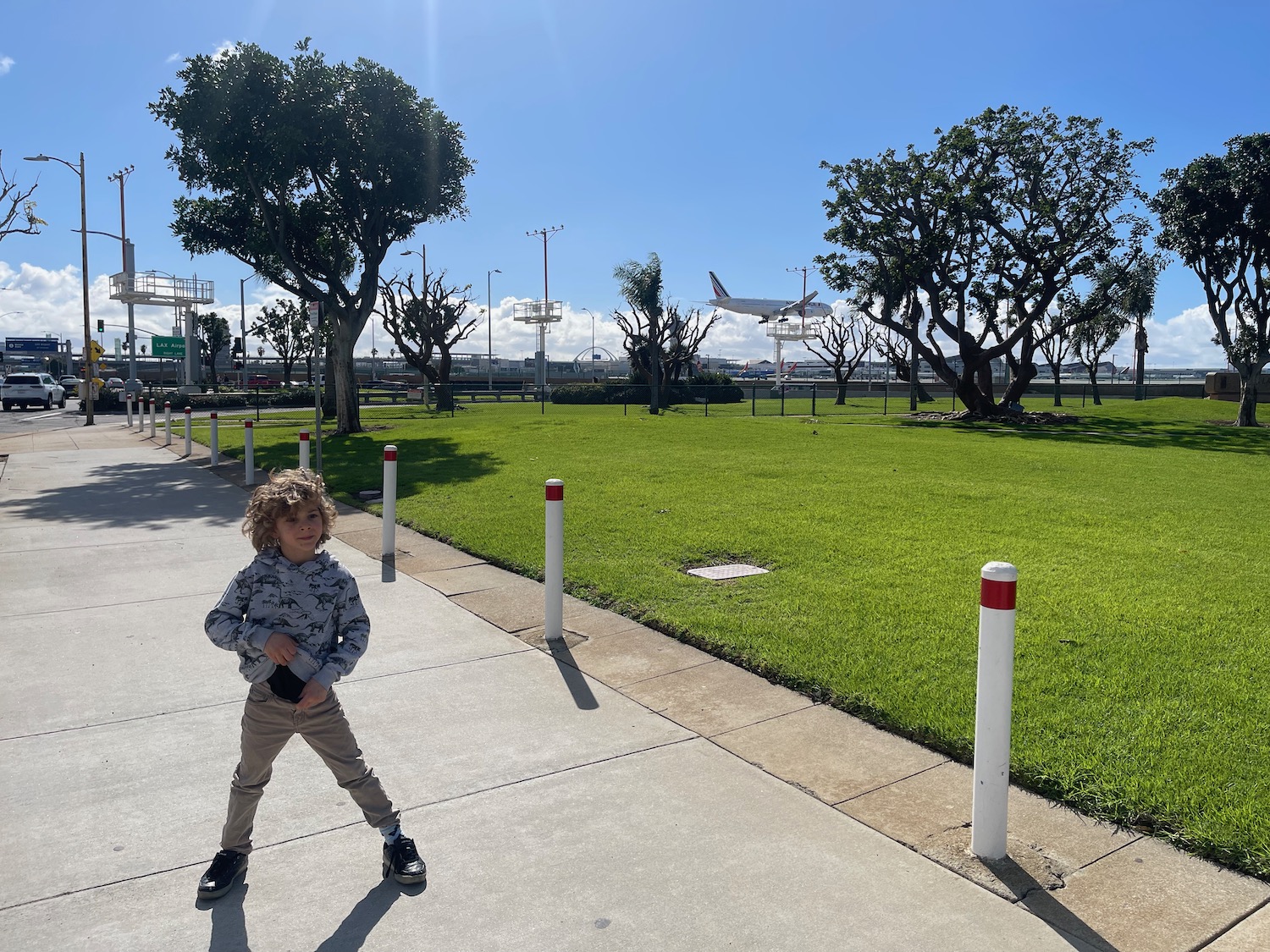 a boy standing on a sidewalk