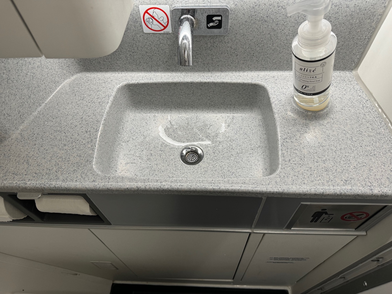 a sink with a soap dispenser and a bottle of liquid on the top