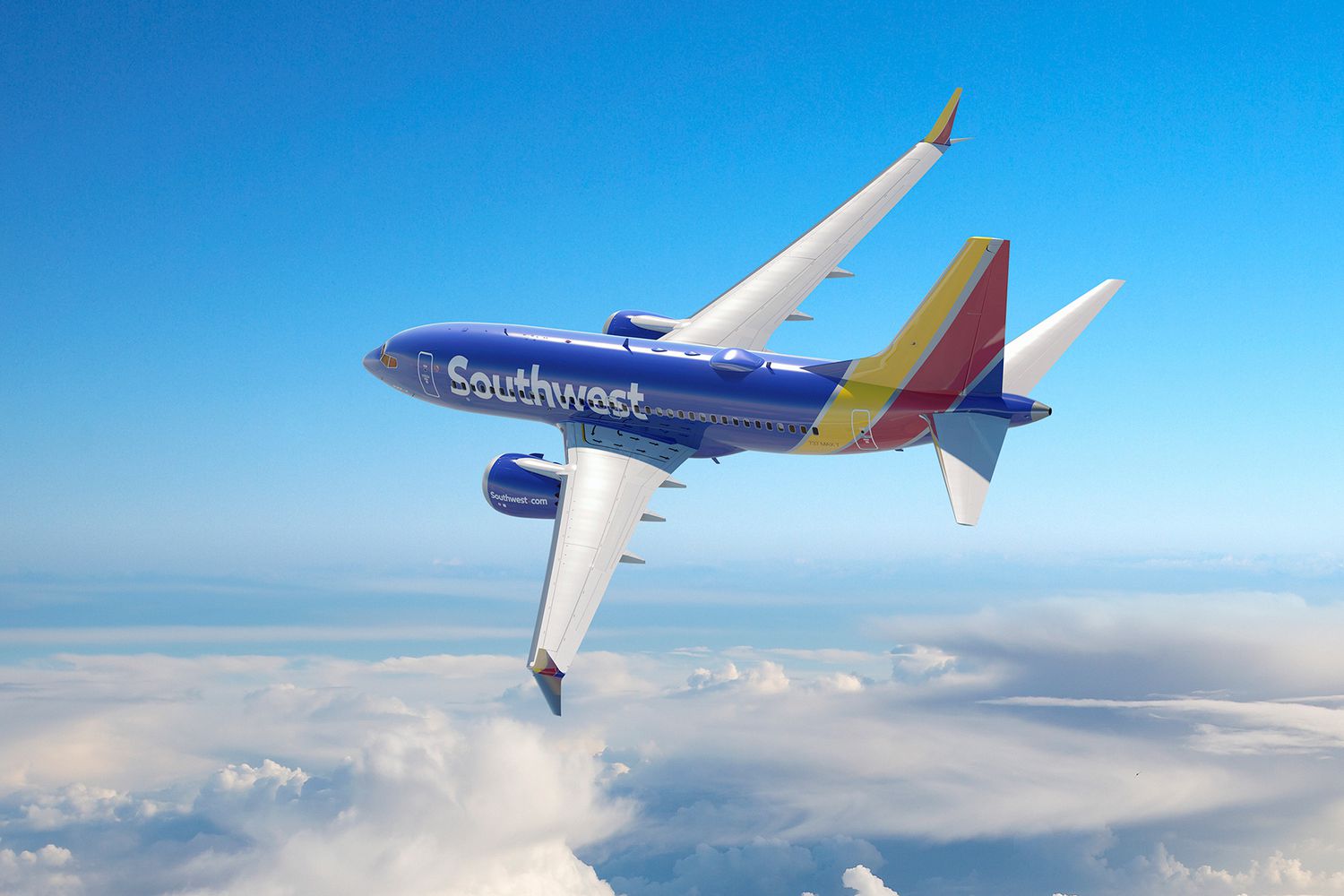 a blue and yellow airplane in the sky