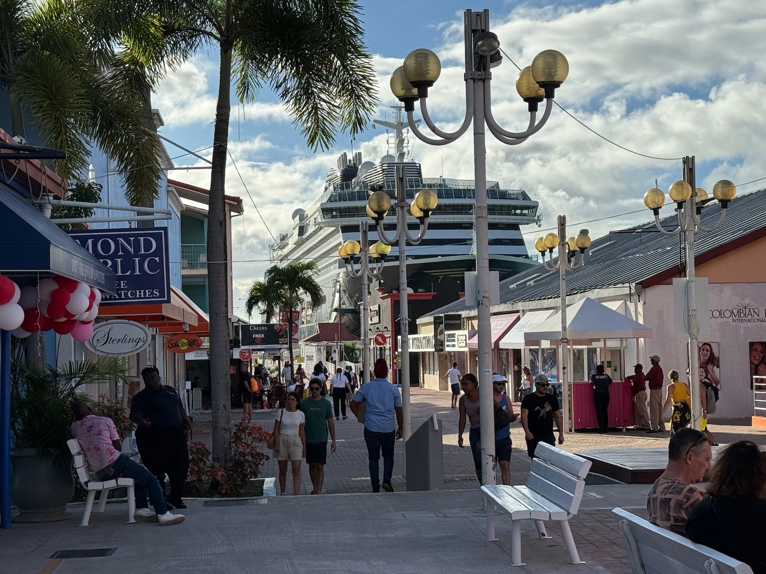 a group of people walking down a street with a cruise ship in the background