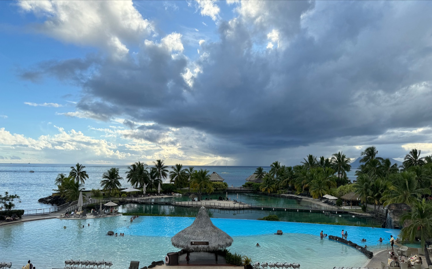 a pool with a hut and a body of water