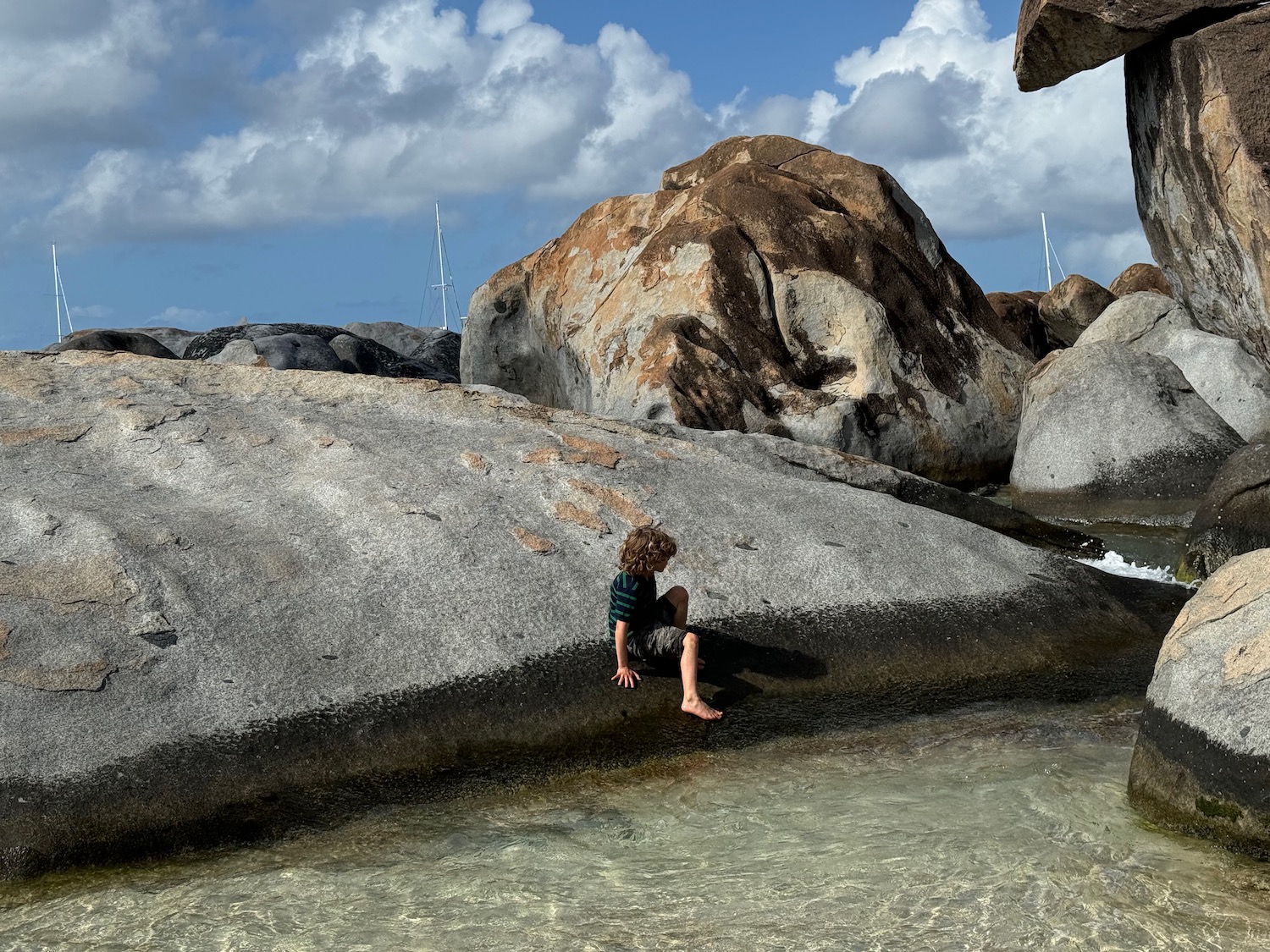 a child climbing on rocks in water