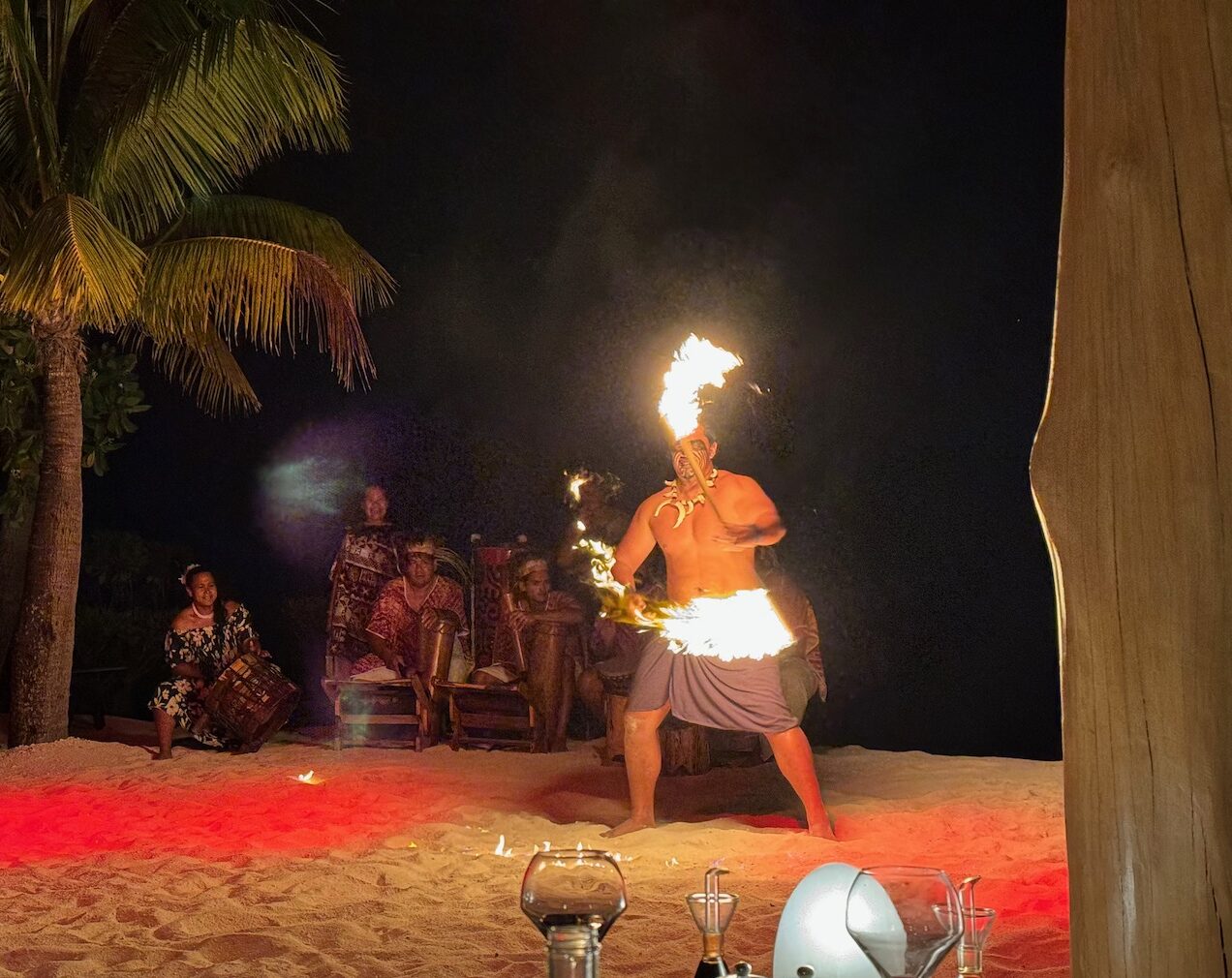 a man with fire on his head on a beach