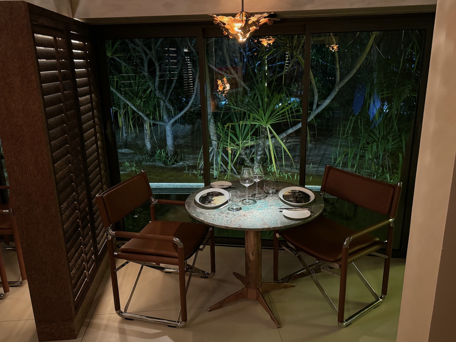 a table with plates and chairs in front of a window