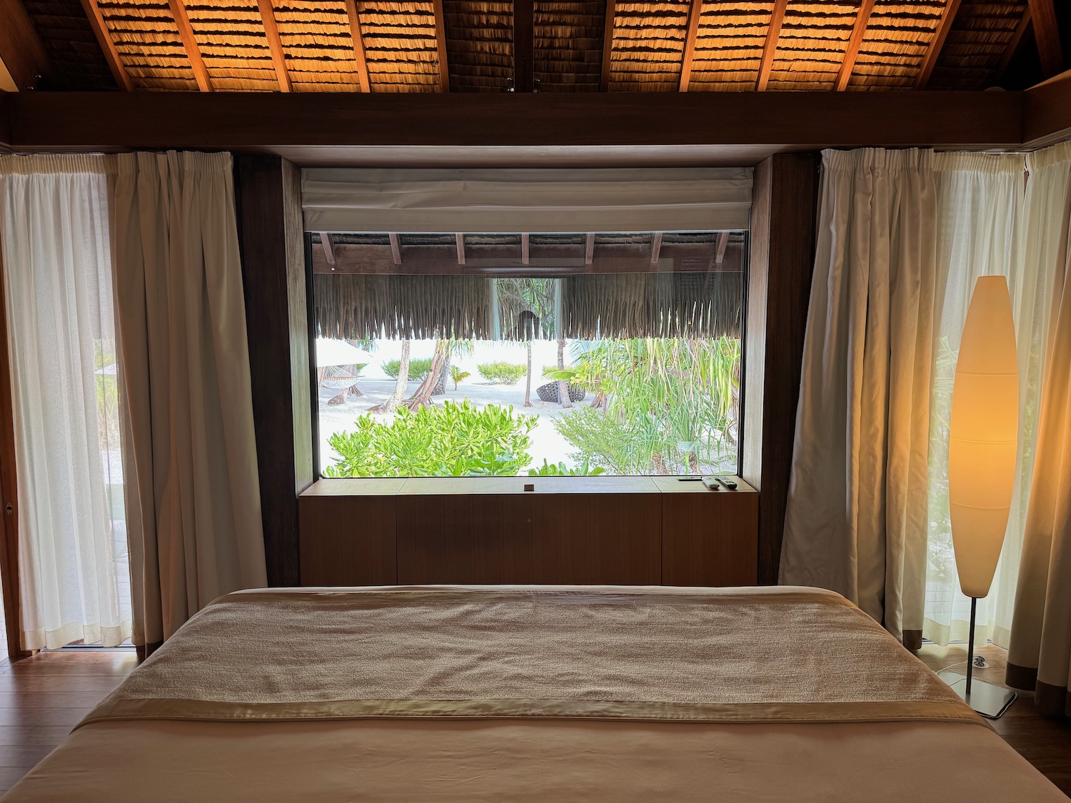 a bed with a window and a straw roof