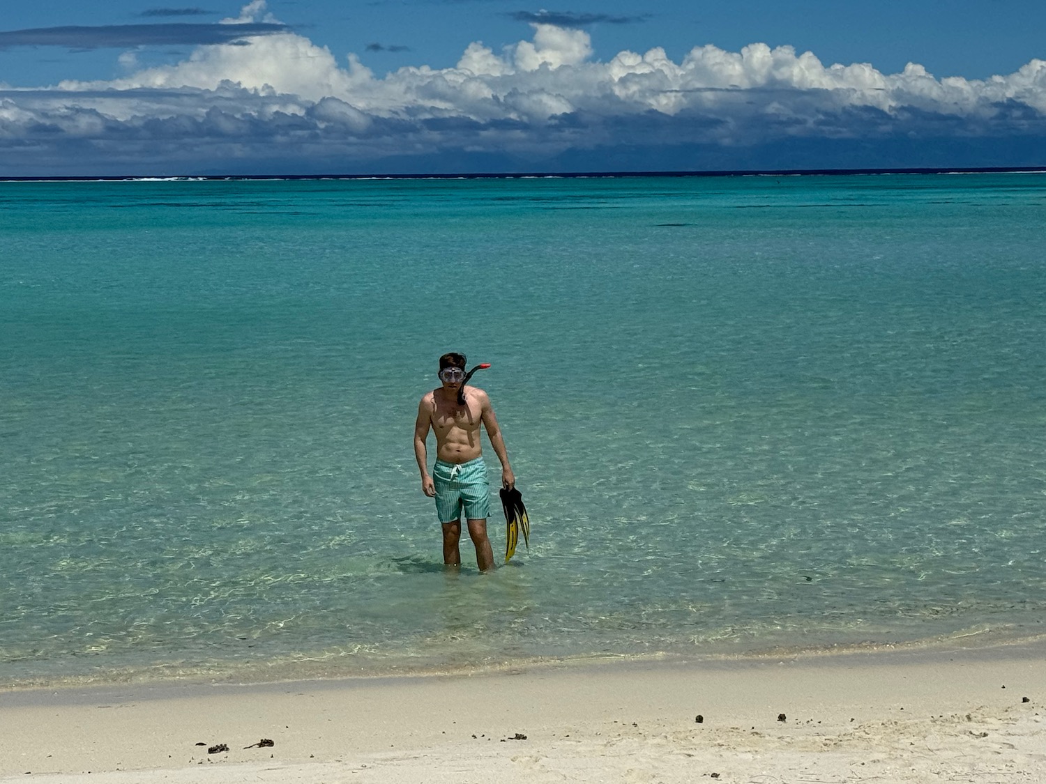 a man standing in the water with snorkel gear