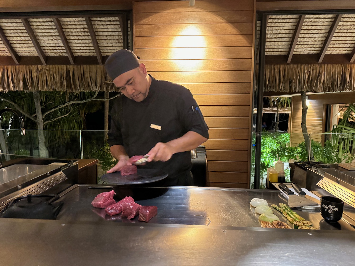 a man cooking meat on a grill