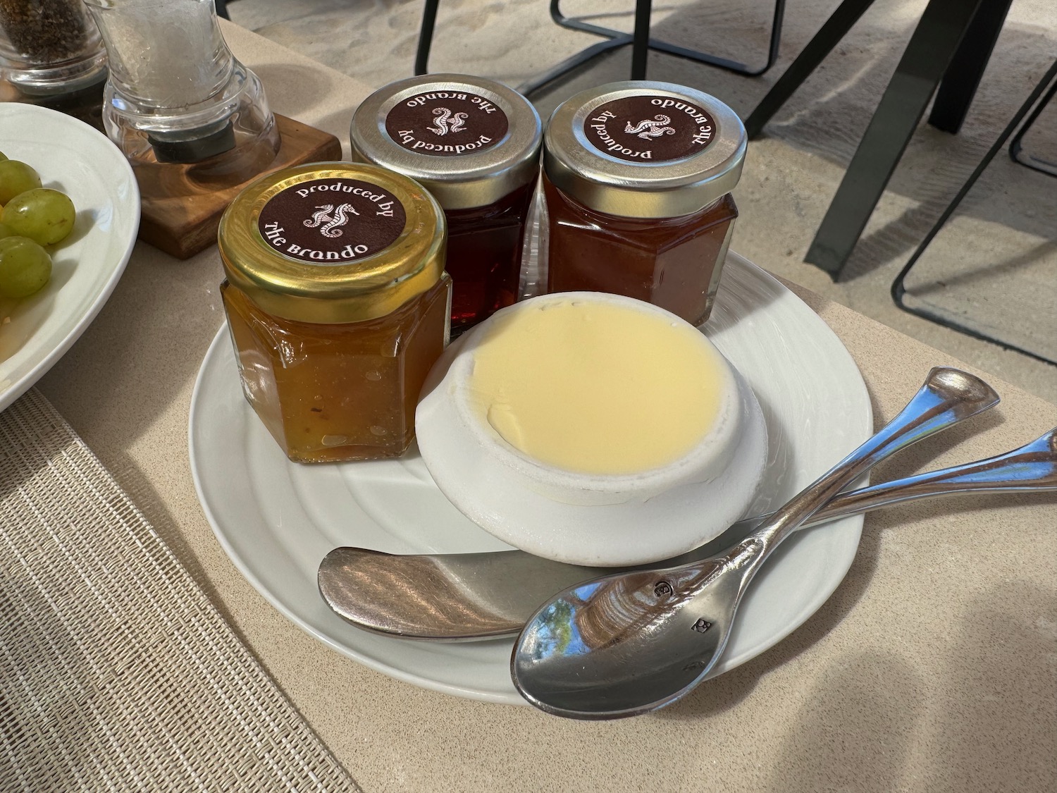 a plate of food with spoons and jars of jam