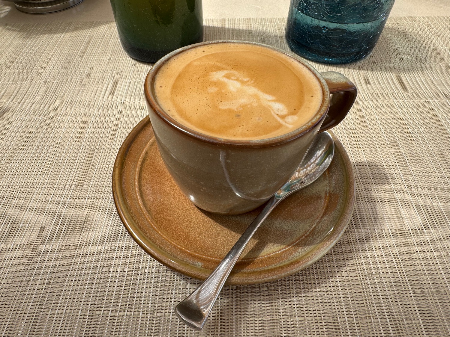 a cup of coffee with a spoon on a saucer