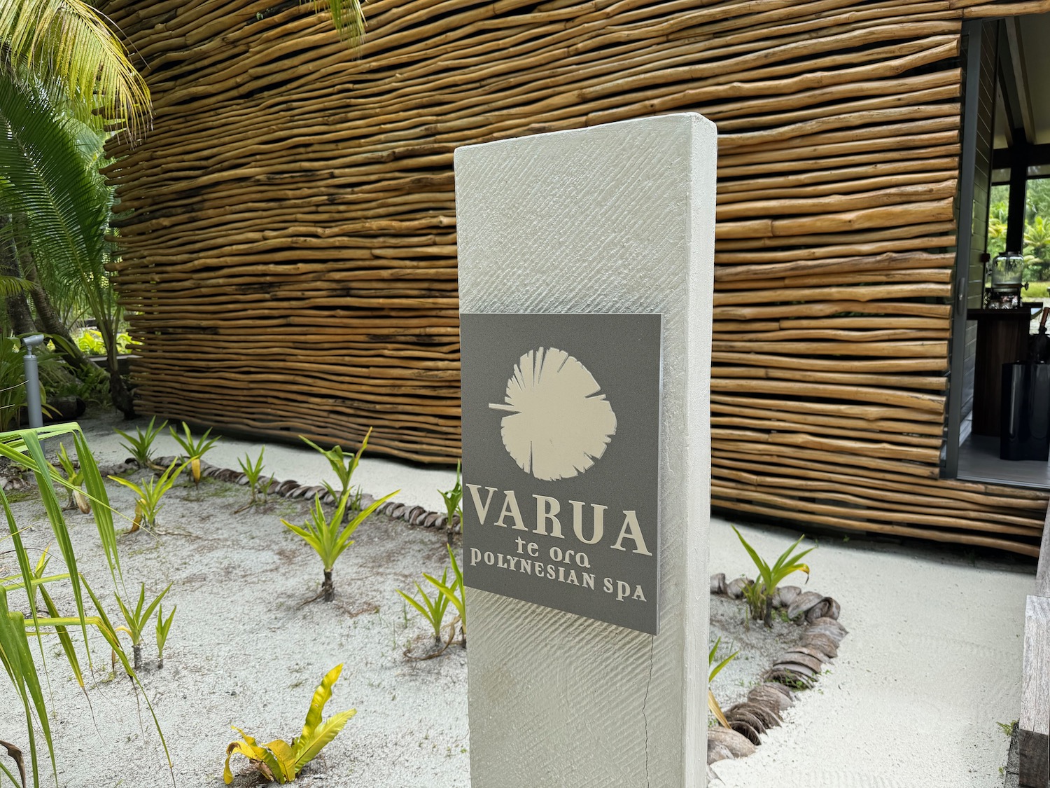 a sign in front of a bamboo wall