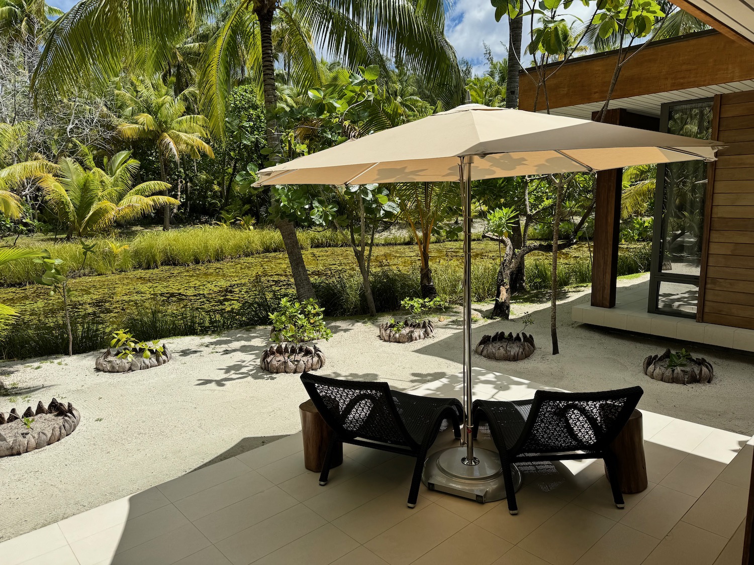 a patio with chairs and umbrella