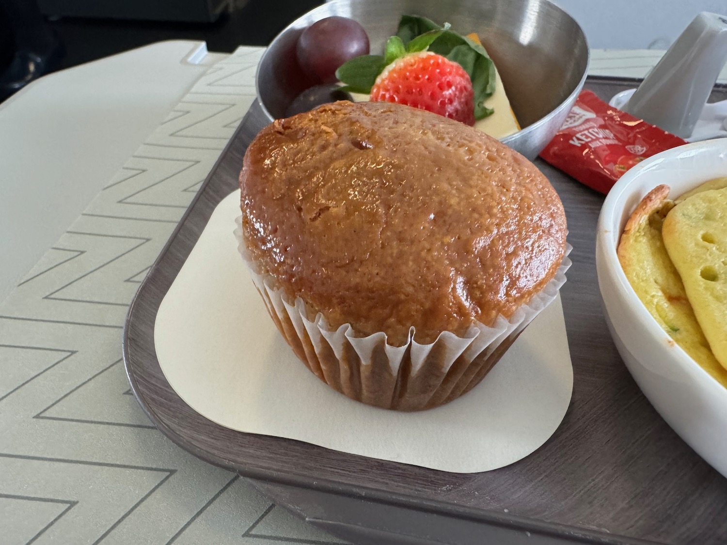 a muffin and fruit on a tray