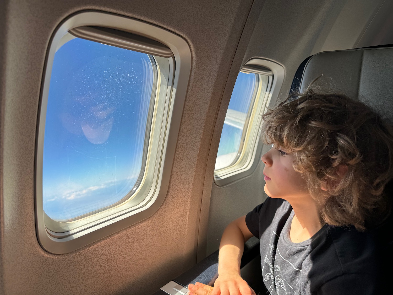 a boy looking out of an airplane window