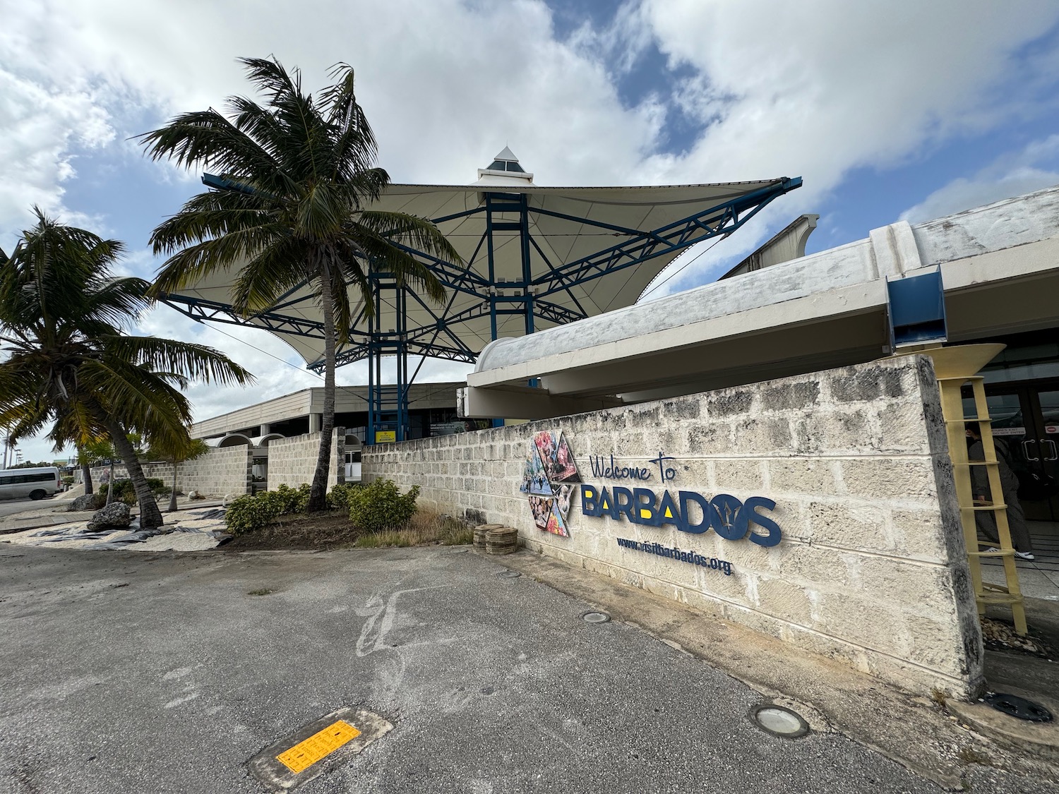 a building with a large roof and palm trees