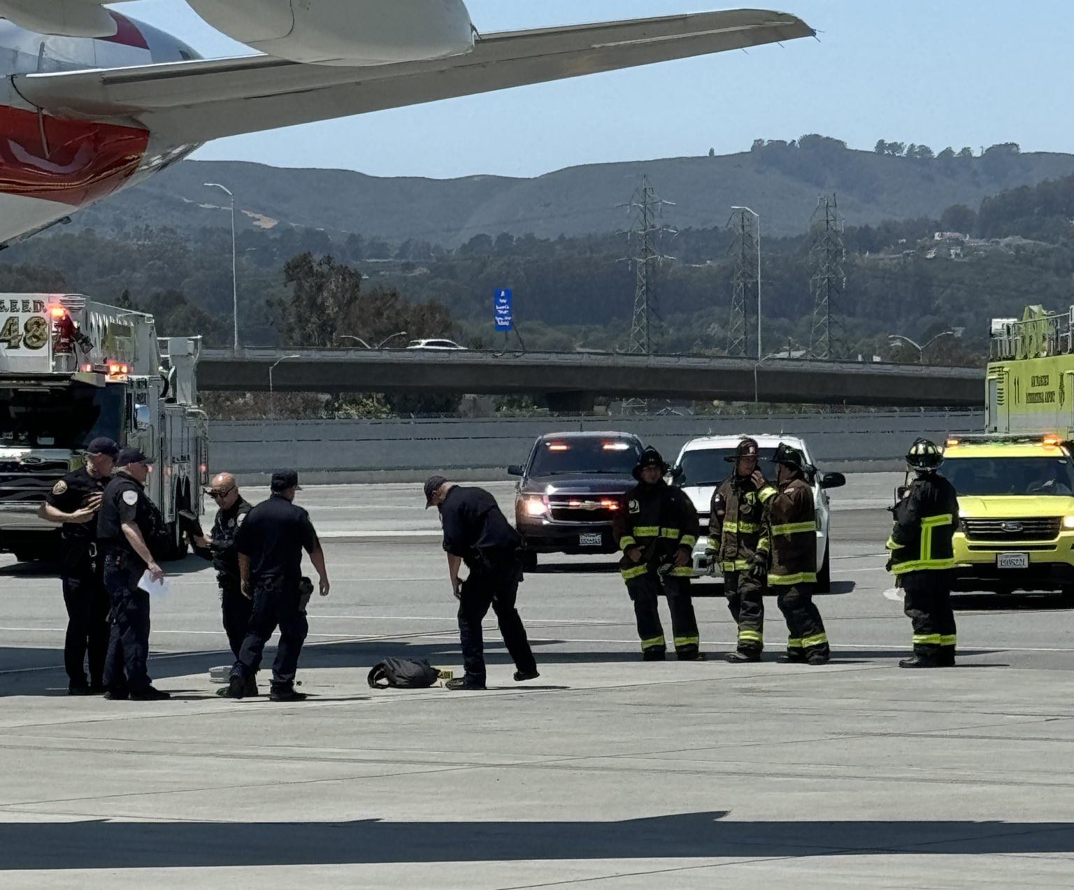 a group of firefighters standing next to a plane
