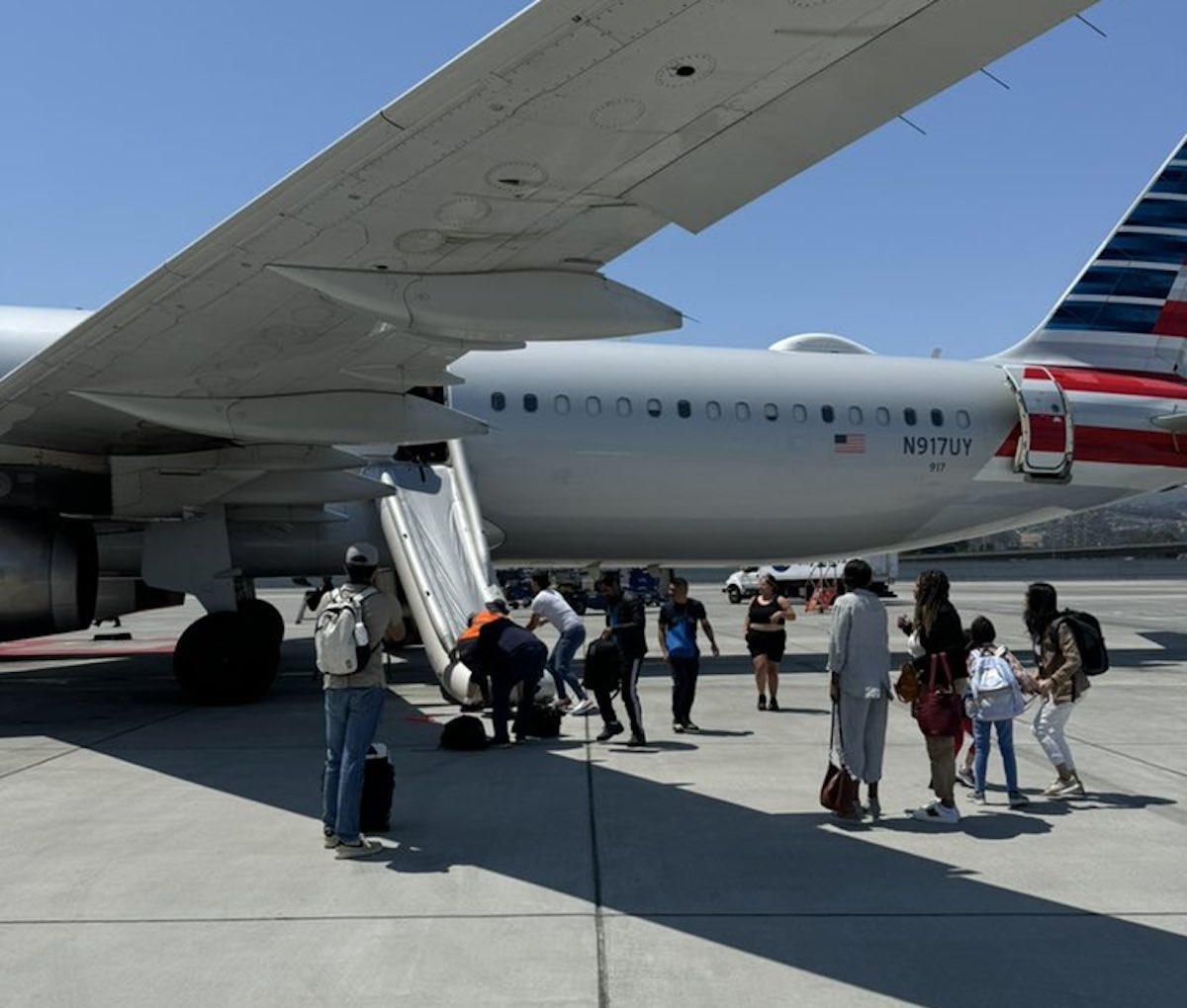 people standing next to an airplane