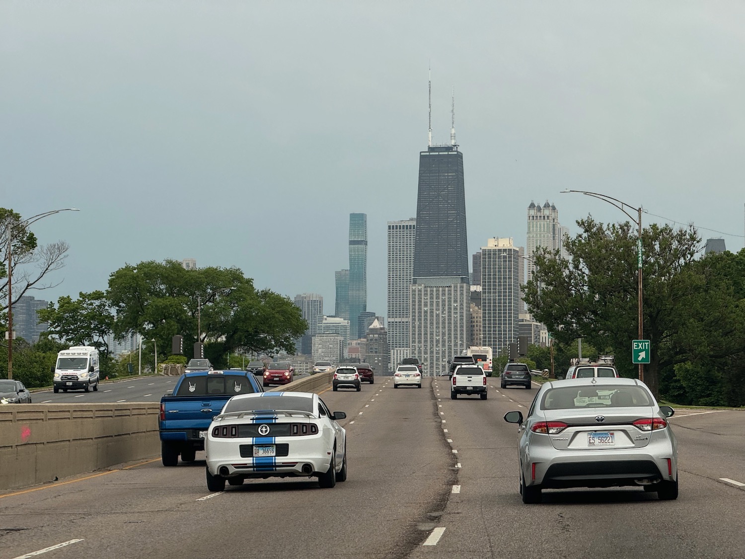 a group of cars on a road with a city in the background
