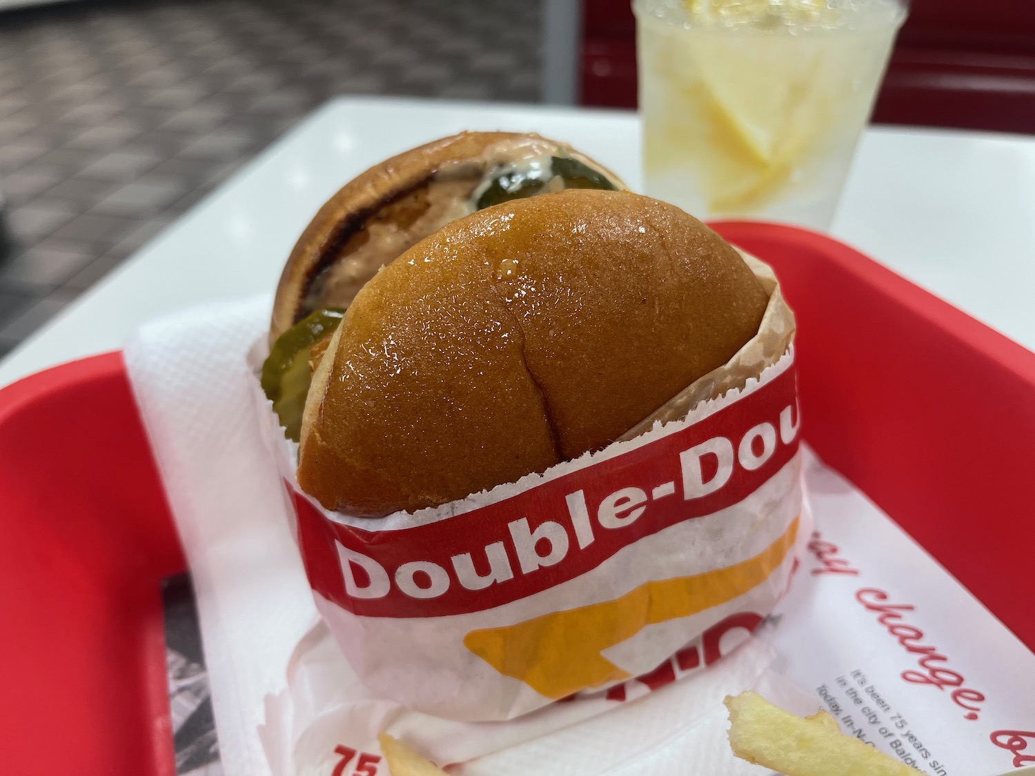 a burger in a wrapper on a tray