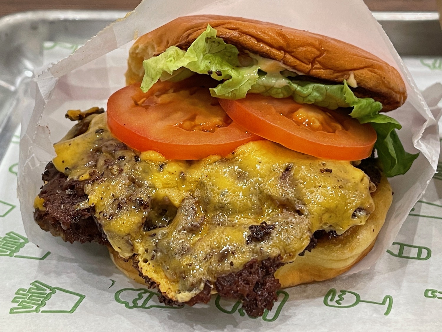 a cheeseburger with tomatoes and lettuce