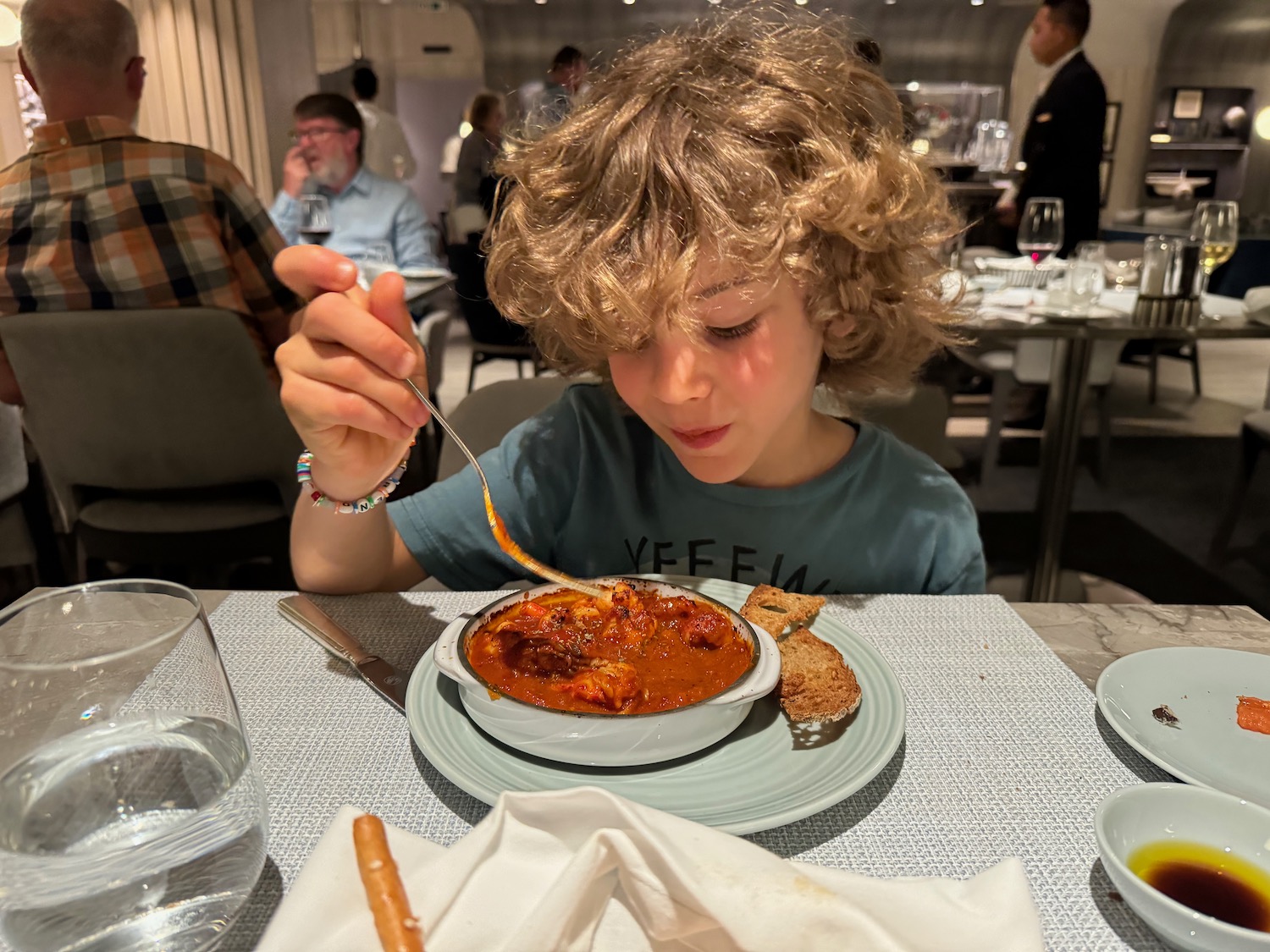 a boy eating a soup