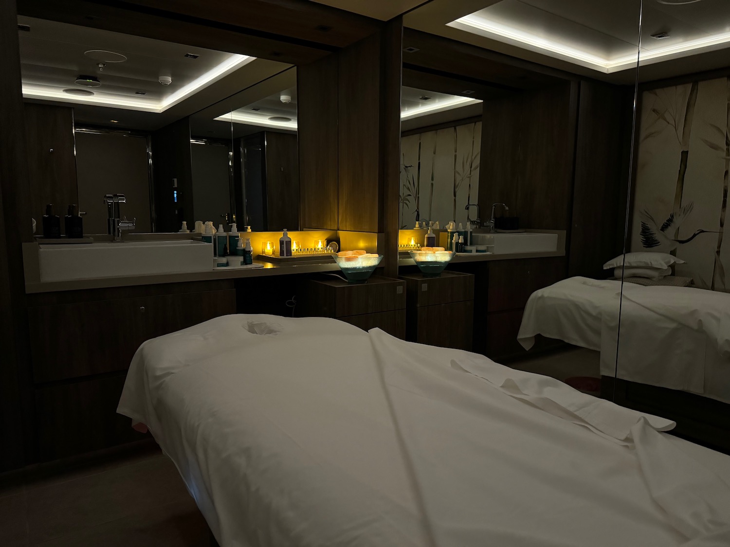 a massage room with a mirror and a bed