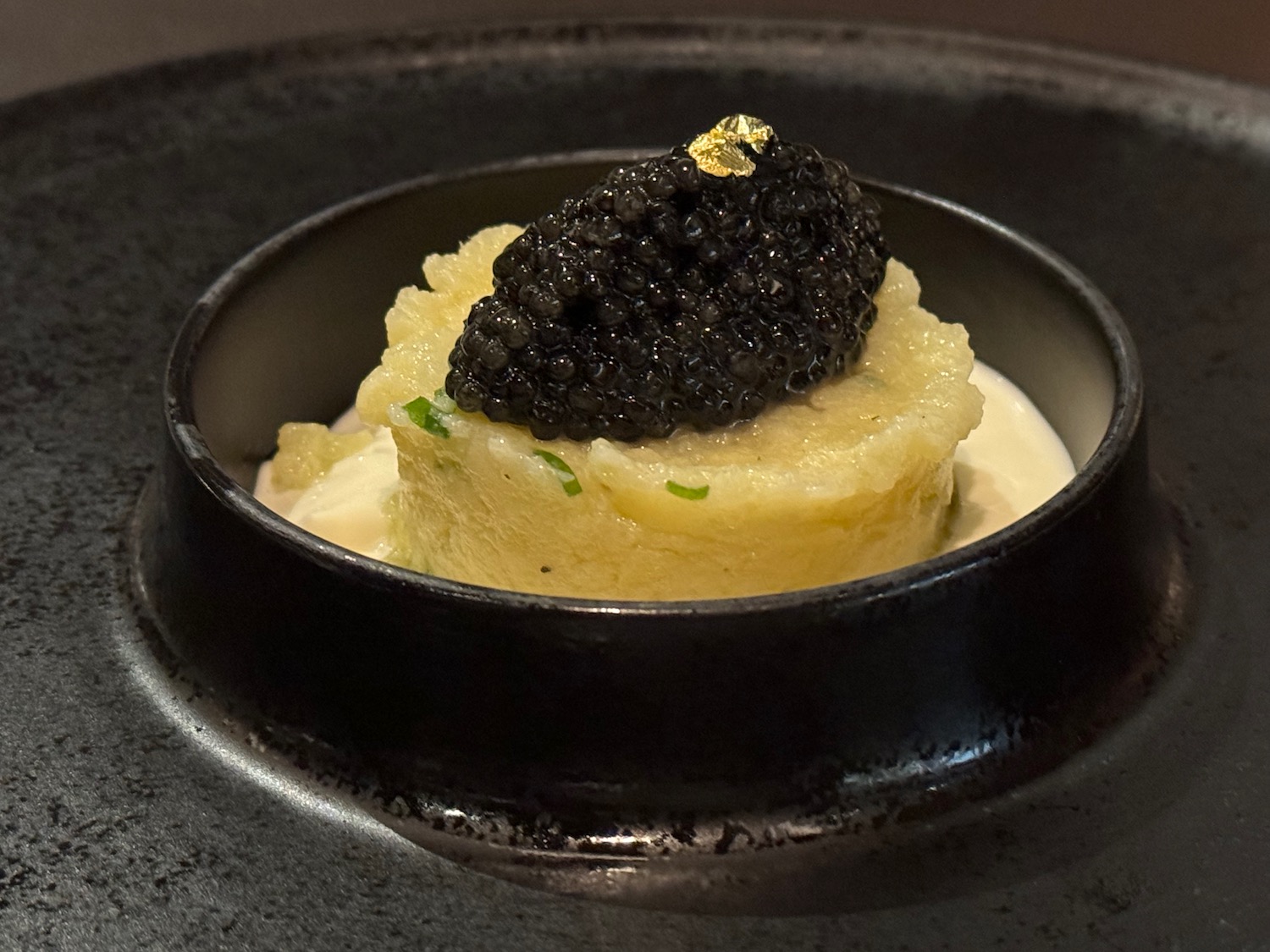 a black dish with black caviar on top