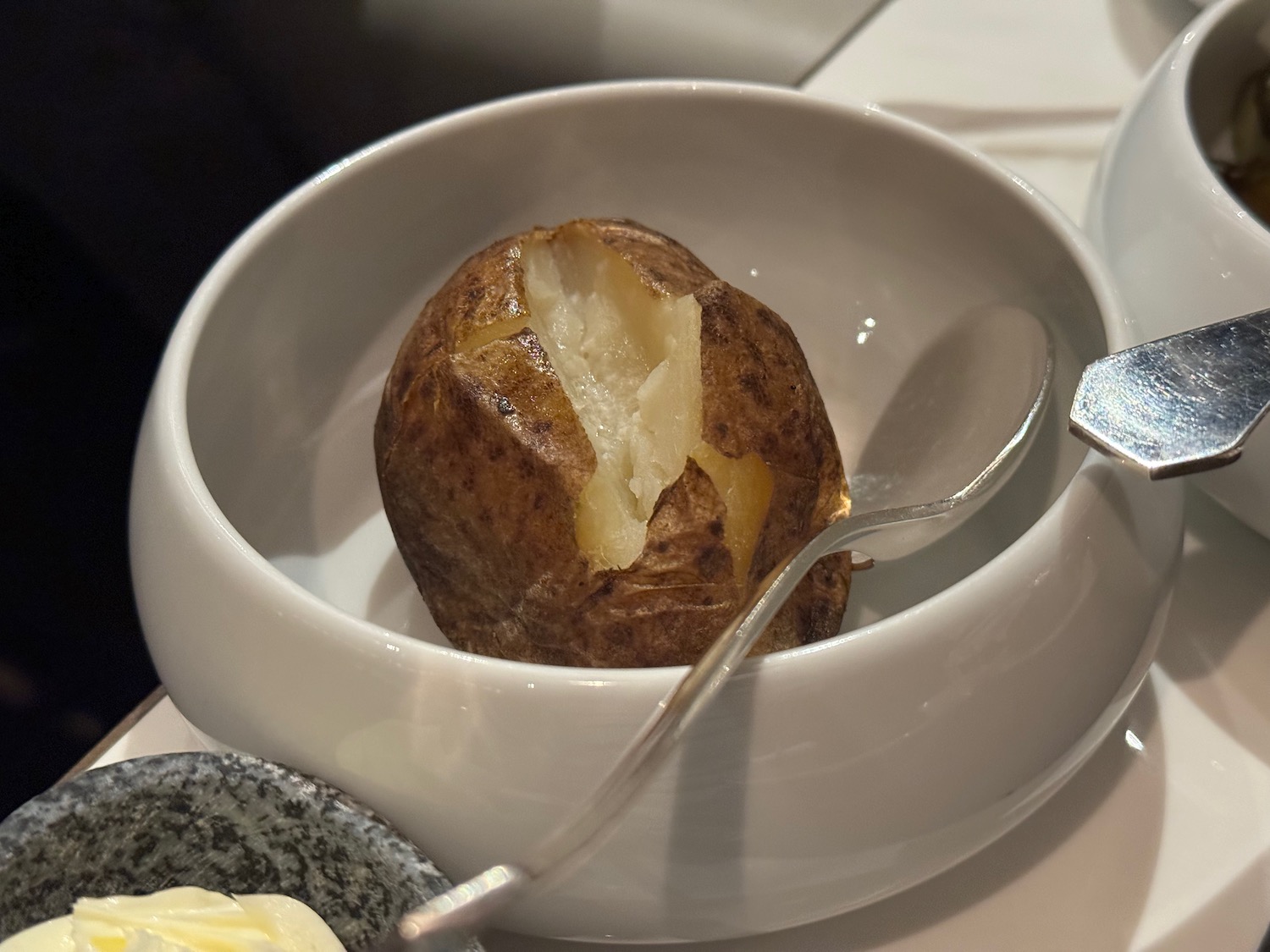 a baked potato in a bowl with a spoon