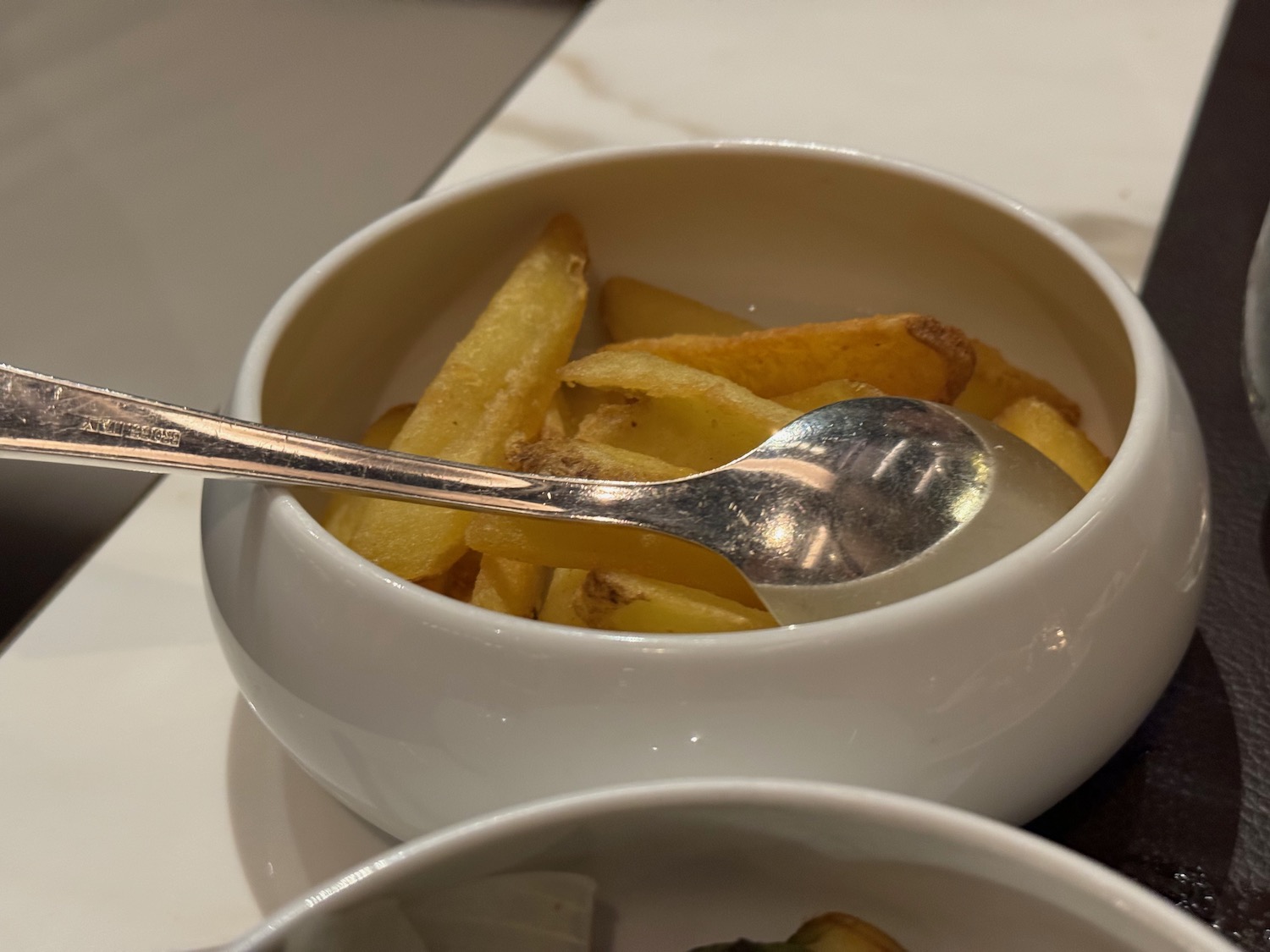 a bowl of french fries with a spoon