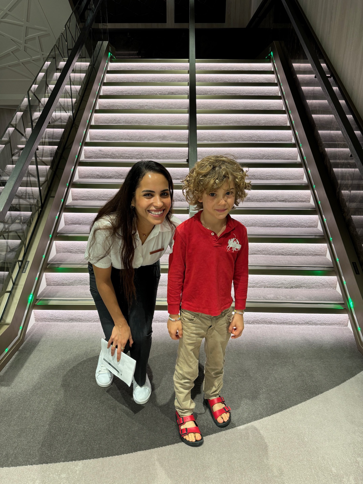 a woman and boy standing on escalator