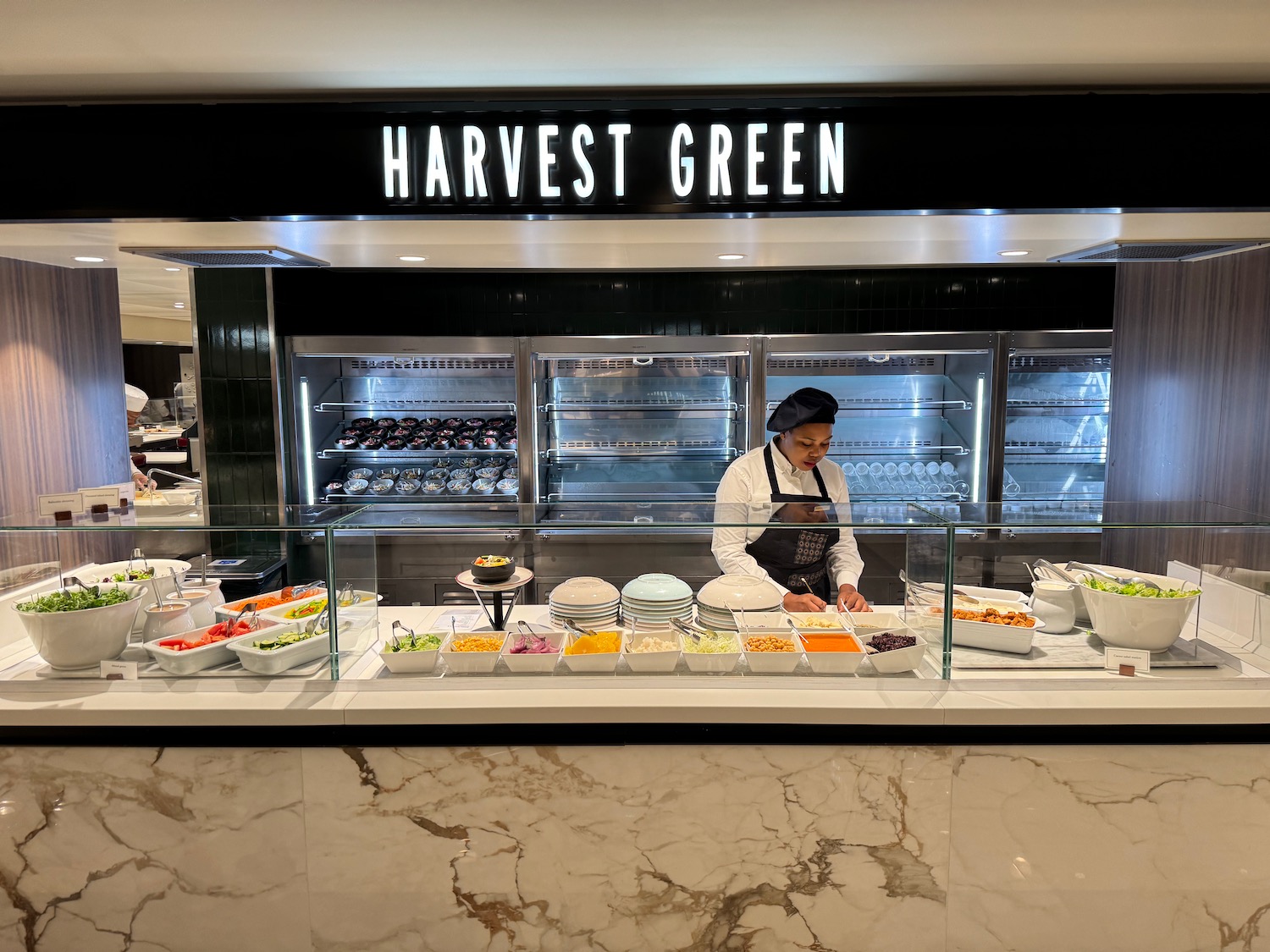 a woman behind a counter with food in a store