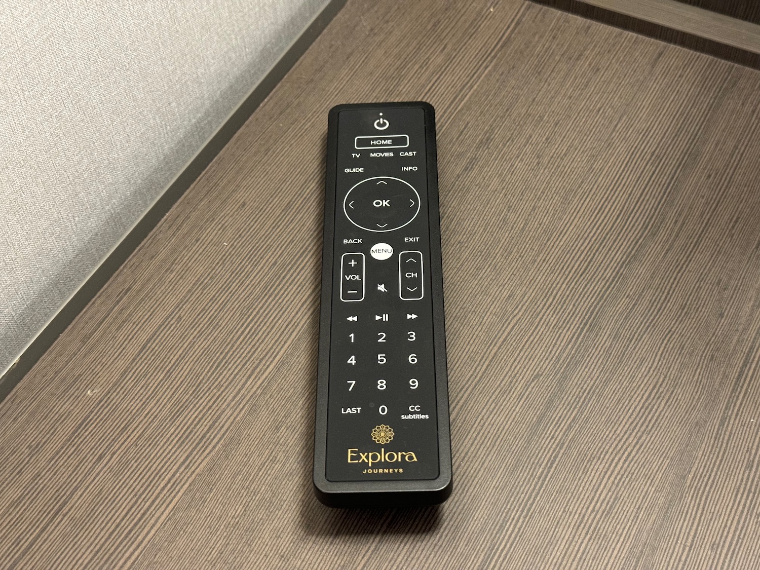 a black remote control on a wood surface