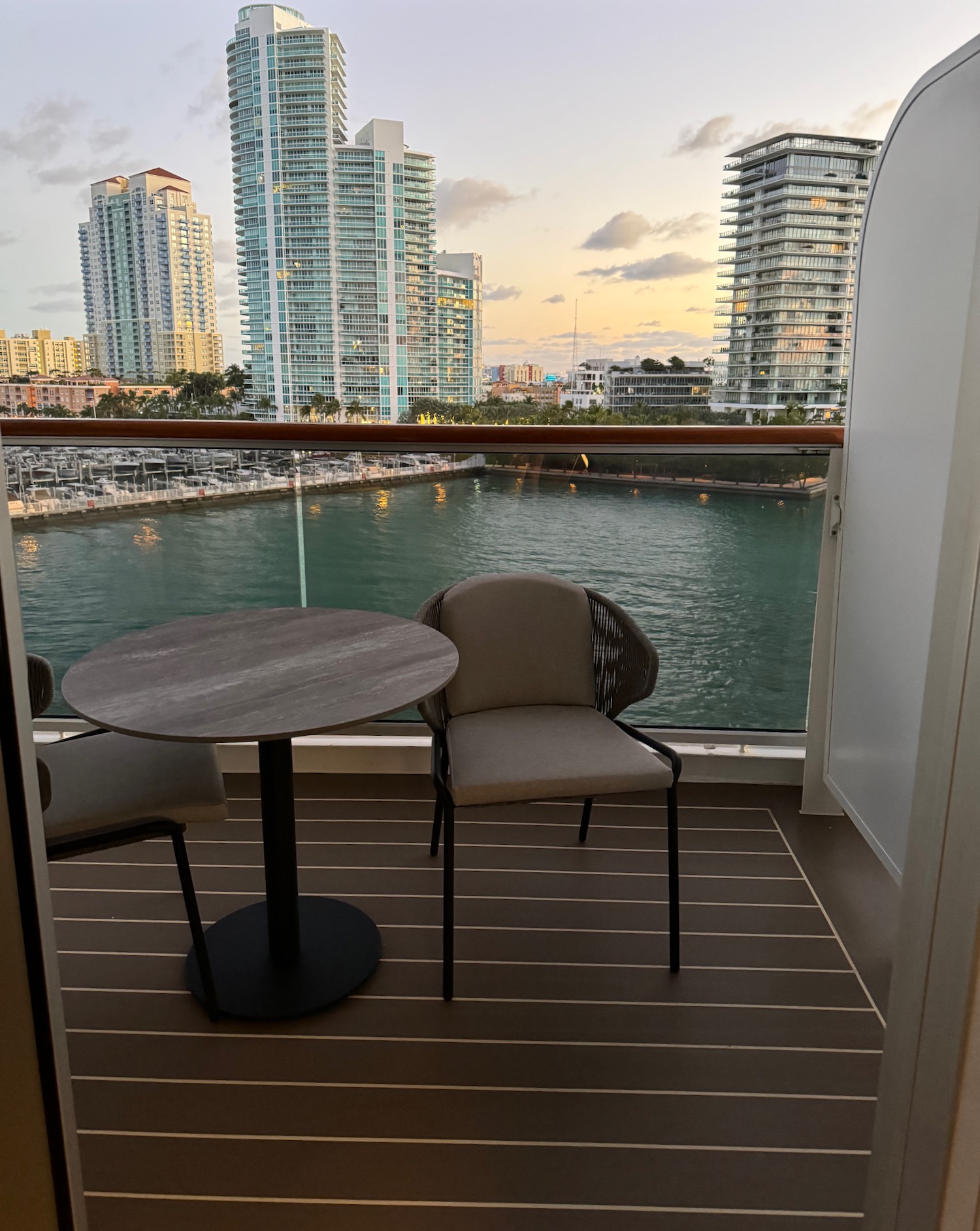 a table and chairs on a balcony overlooking a body of water