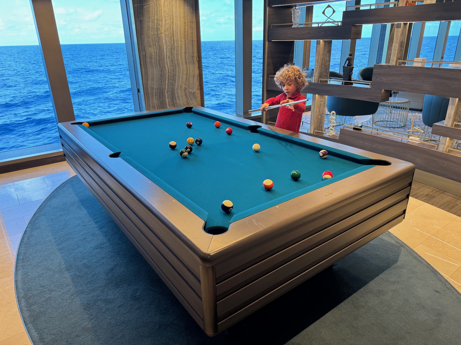 a child playing pool with a pool table