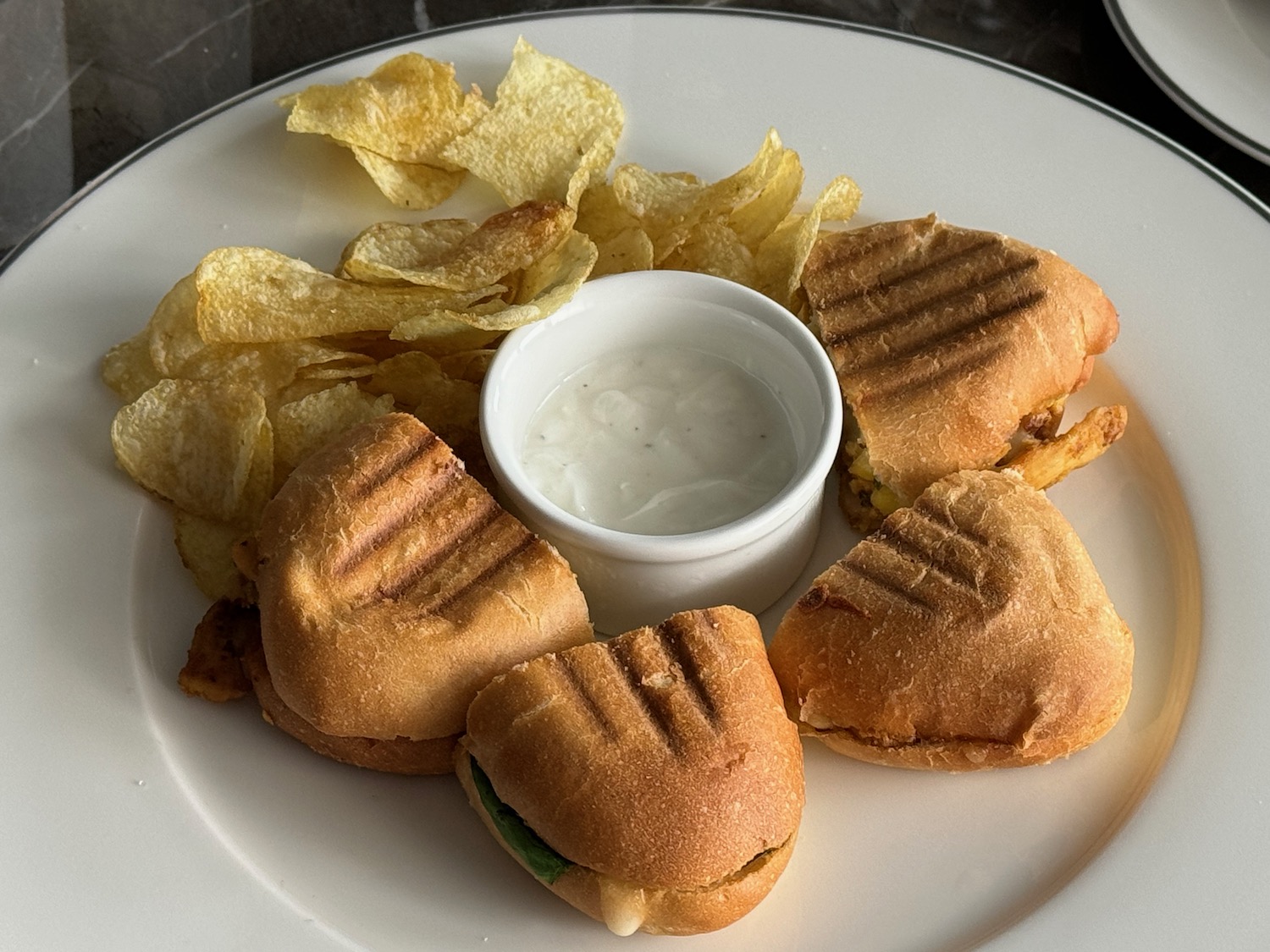 a plate of food with a white cup and sauce