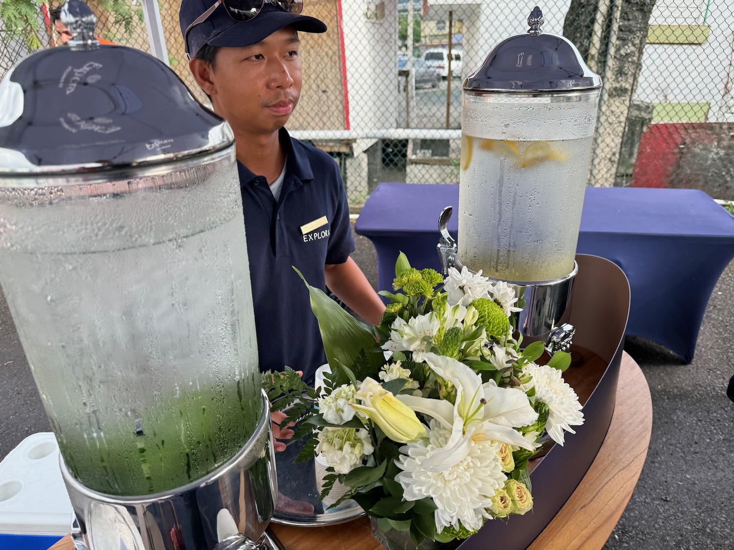 a man standing behind a table with a drink dispenser