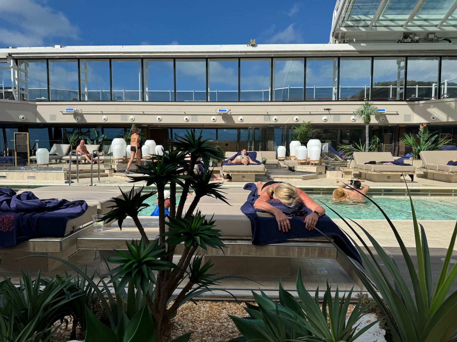 a woman lying on a lounge chair next to a pool