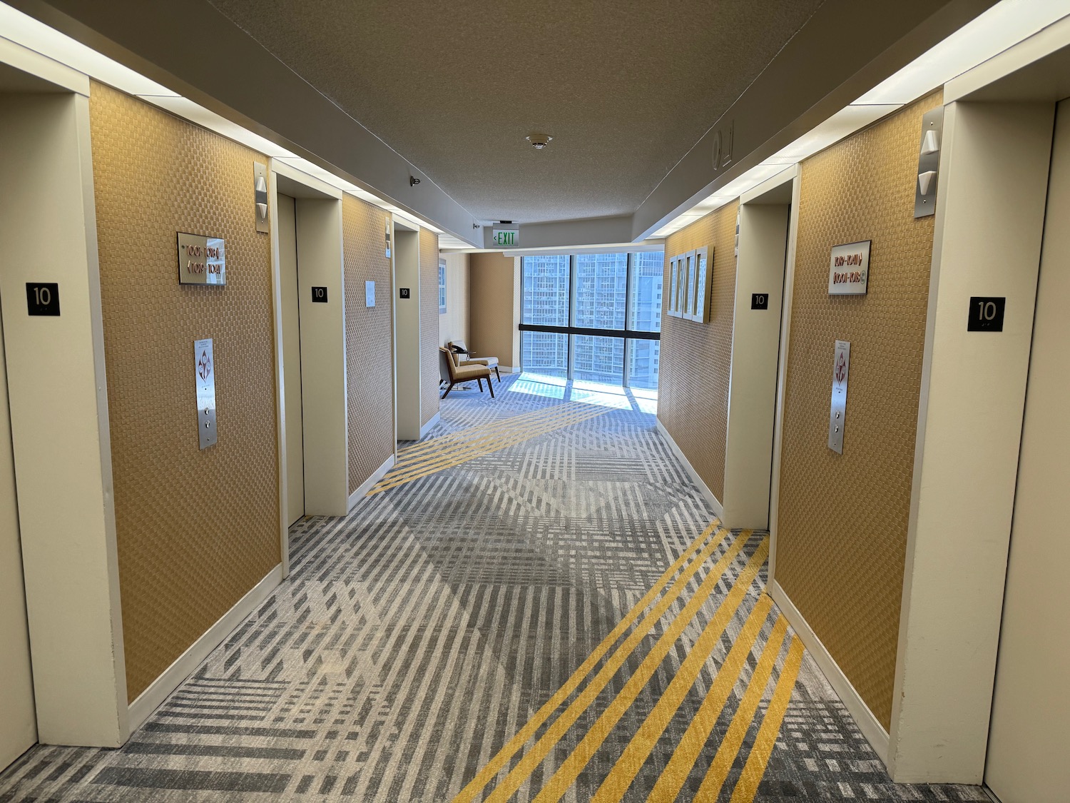 a hallway with elevator doors and a chair