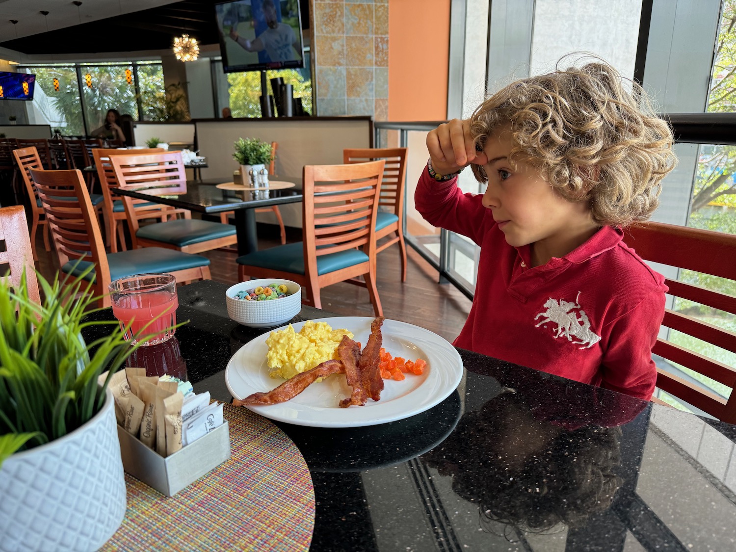 a child sitting at a table with a plate of food