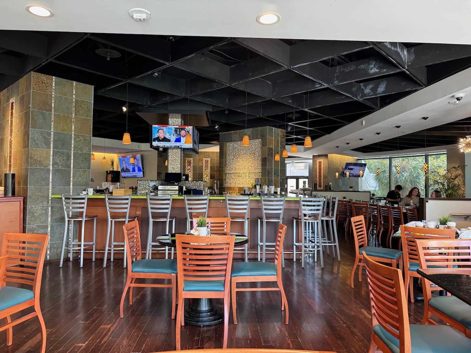 a room with a bar and tables and chairs